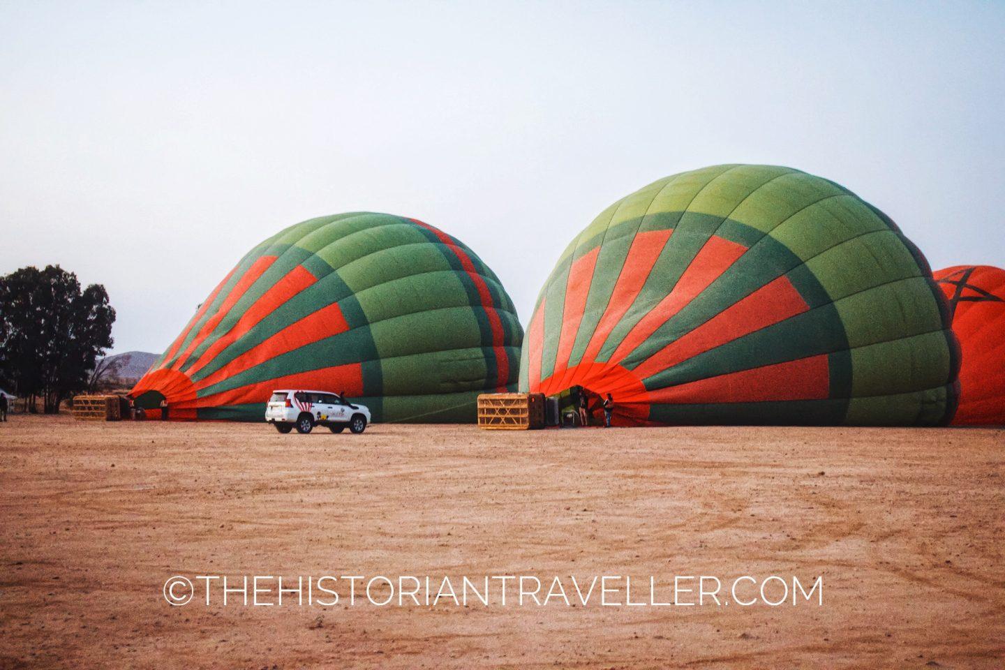 Two inflating hot air balloons and a car in Marrakech